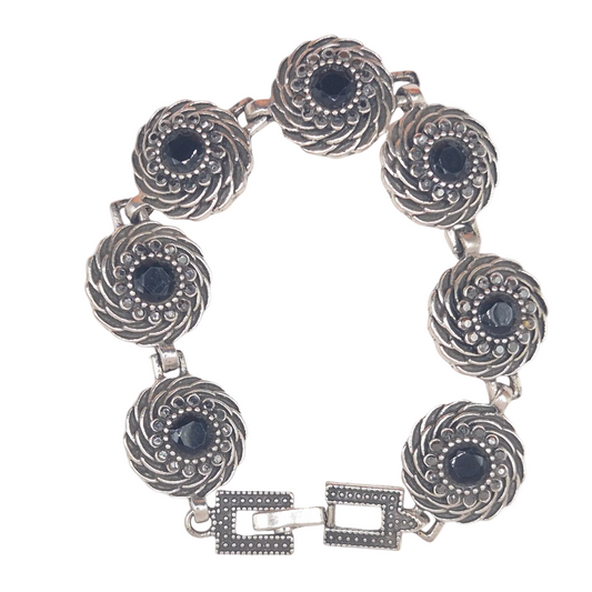 Black flower on spiral in brass